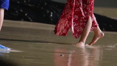 Sahilde kırmızı elbiseli bir kadın.