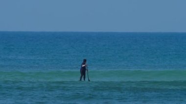 Okyanustaki SUP panosundaki kız.