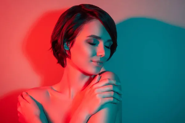 Foto de relajado alegre soñador impresionante peinado corto mujer abrazarse aislado rojo neón luz color fondo —  Fotos de Stock