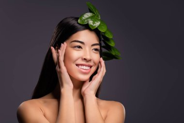 Olumlu, neşeli, hayalperest, güzel model kadının fotoğrafı. Saçları boş görünüyor. İzole edilmiş gri arkaplan.