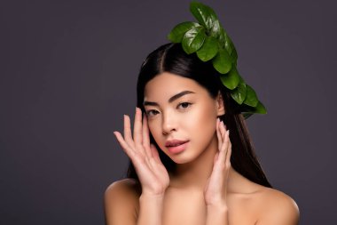 Çekici model kadının fotoğrafı elmacık kemiklerine dokununca soluk gri renkli arka plan ortaya çıkıyor.