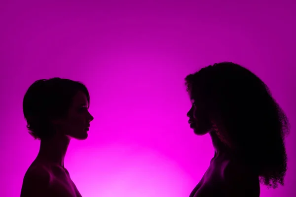 Profil boční pohled dvě atraktivní svůdné nahé ženy vs rodina izolované přes živé fialové fialové šeříkové barvy pozadí — Stock fotografie