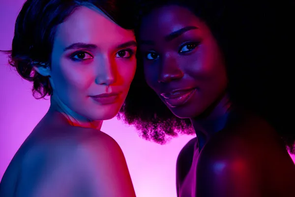 Portret van twee aantrekkelijke vrouwen bonding genieten romantiek zoet flirterig geïsoleerd violet paars neon kleur achtergrond — Stockfoto