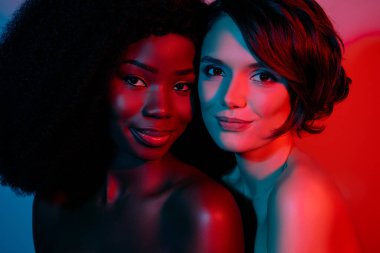 Canlı neon mavisi gradyan arka planda izole edilmiş iki çıplak, tatlı kadının kesikli portresi.