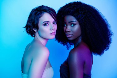 Çok güzel iki kişinin profil portresi başlarını çeviriyor. Neon ışıklı arka planda izole kameraya bak.