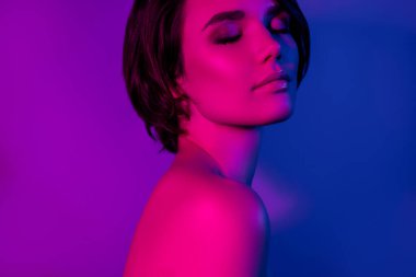 Yan profil fotoğrafı. Barışçıl kız çıplak omuzlar. Kısa saç elbisesi, rüya gibi izole edilmiş mavi bir arka plan.