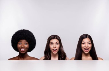 Mutlu gülümseyen üç genç kızın fotoğrafı. Gri arka planda mahsur kalmış hayret verici bir cilt.