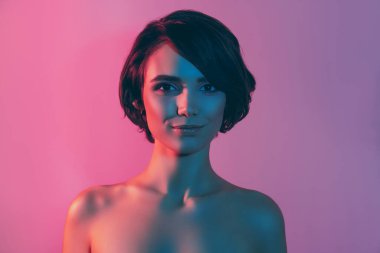 Fotoğraf portresi sakin güzel kız çıplak omuzlar kısa saç stili giyinmiş izole edilmiş neon rengi arka plan.