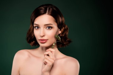 Yüzünde mezoroller olan gülümseyen bir kadının yeşil arkaplanda izole edilmiş spa prosedürü.