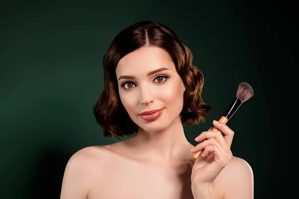 Retrato de chica maquilladora profesional cool con hombros desnudos sostienen cepillo grande aislado sobre fondo de color verde —  Fotos de Stock