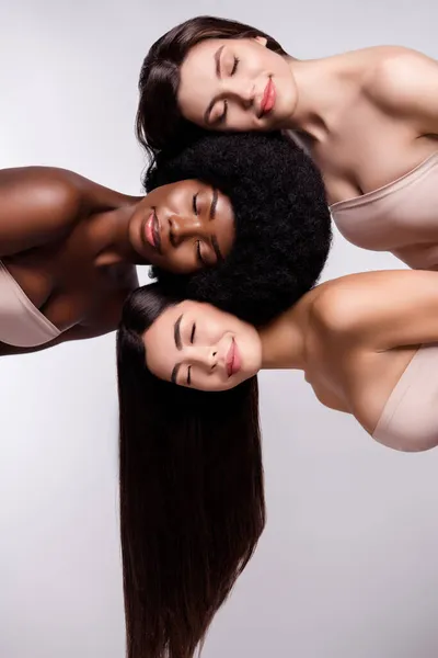 Foto de três jovens meninas atraentes sorriso positivo feliz desfrutar de salão de cuidados com a pele isolado sobre fundo de cor cinza — Fotografia de Stock