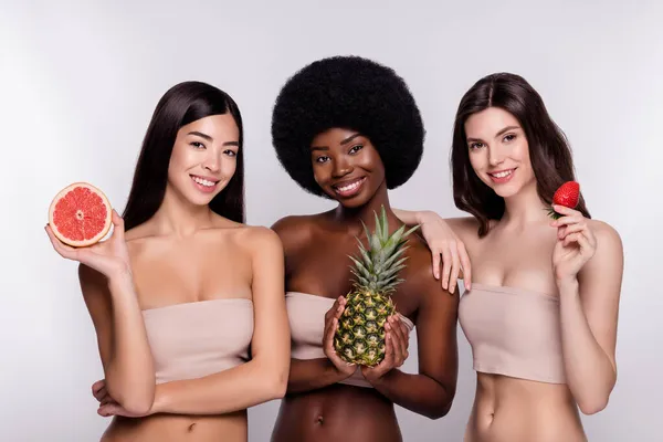 Foto di tre giovane donna felice sorriso positivo tenere frutta dieta cura del corpo isolato su sfondo di colore grigio — Foto Stock