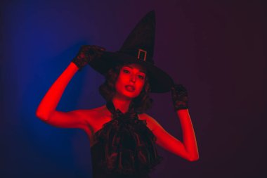 Mistik kadının çekici fotoğrafı siyah elbiseler giyiyor kolları gotik başlık, izole edilmiş koyu kırmızı renk arka plan.