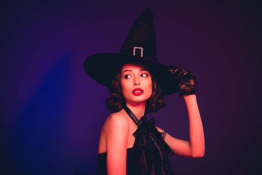 Baştan çıkarıcı mistik kadının fotoğrafı. Siyah elbiseler giyip kollar takıyor. Geriye dönüp, izole edilmiş koyu renk arka plan.