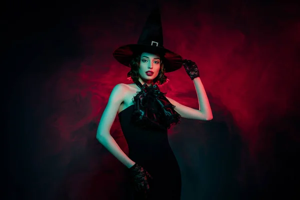 Фото очаровательной сексуальной загадочной женщины носить готическое платье ведьмы руки головной убор изолированный красный туман цвета фона — стоковое фото