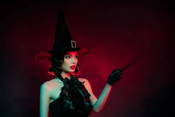 Photo of frightening mystic lady wear black dress point magic wand empty space isolated dark red smoke color background — Stock Photo, Image