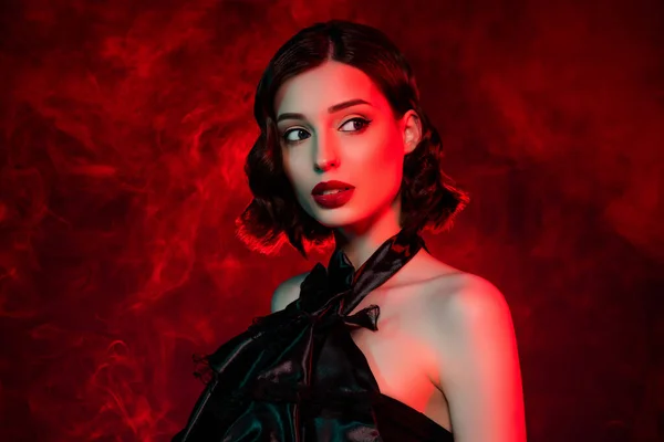 Çekici hayalperest kadının kırmızı pokus giydiği fotoğraf boş görünüyor. Neon sisli arka planda izole edilmiş hayal et.
