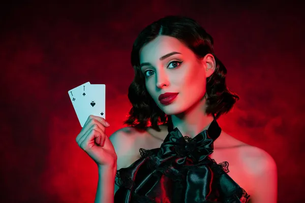 Fotografie ohromující elegantní stylové mladé ženy držet ruce eso karty poker hráč izolovaný na pozadí neonového filtru — Stock fotografie