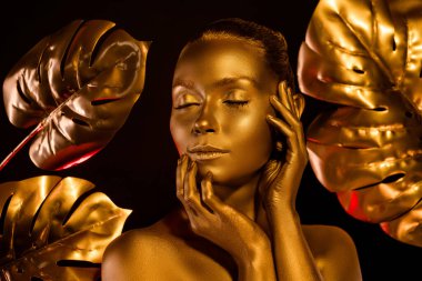 Altın kaplamalı göz kamaştırıcı heykelin portresi. Çiçekli, karanlık ormandaki memnuniyetten gözlerini kapat.