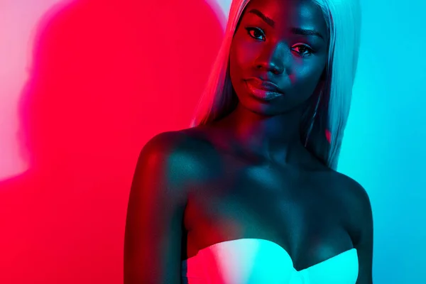 Photo of young beautiful stunning attractive elegant african woman in blonde wig isolated on colorful neon background — Foto de Stock