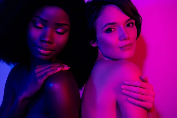 Portrait of two naked women caressing shoulders flawless smooth skin isolated over bright neon purple color background — Foto de Stock