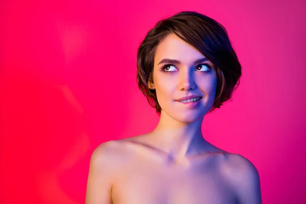 Photo of sweet brunette hairdo young lady bite lip look empty space isolated on vibrant neon red color background — Stockfoto