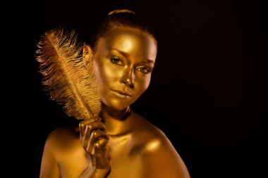 Göz kamaştırıcı görünüş karanlık tanrıça bayan altın tüyü tut gerçek şehvetli gözlerin görünmesi için hazır tut