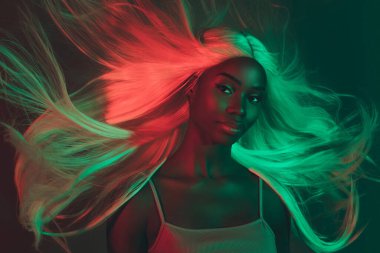 Sevimli kibar bir bayanın portresi koyu arkaplandaki spa ameliyatından sonra ışıltılı ve güçlü saçlar sergiliyor.