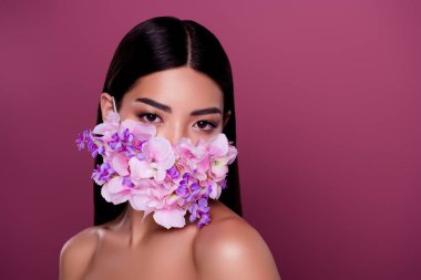 Çevresel çiçek maskesi takan hassas bir kadının portresi onu pembe arka planda izole edilmiş siyah polenden koruyor..