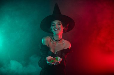 Karanlık kadın büyücünün fotoğrafı cadılar bayramı temalı marmelat şekerlerini izole edilmiş mistik duman rengi arka planında gösteriyor..