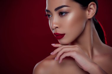 Lüks bir bayanın yakın plan fotoğrafı. Parti etkinliği için hazırlan. Süslü ruj, yakut rengi arka planda izole..