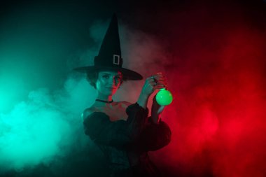 Korkutucu karanlık büyücü kadının fotoğrafı. Parlak renk arkaplanda izole edilmiş güçlü bir aşk iksiri hazırla..