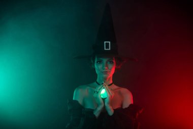 Kadın büyücünün okültizm yaparken çekilmiş fotoğrafı. Kırmızı arkaplanda izole edilmiş değerli taş kolye kullanılmış..