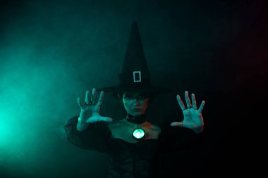 Kötü kalpli güçlü kadın büyücünün fotoğrafı kara büyü yapıyor mistik sisli arka planda izole edilmiş elleri hareket ettiriyor..