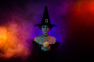 Büyücü kadının korku büyüsü yaptığı fotoğraf. Renkli arka planda izole edilmiş mum ateşi..