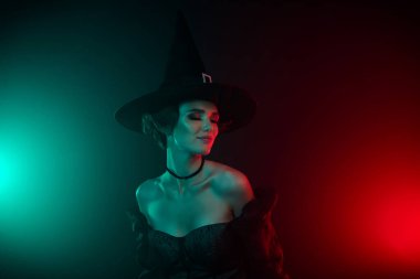 Çekici bayan vampirin mistik renkli arka planda izole edilmiş dolunayın tadını çıkardığı bir fotoğraf..