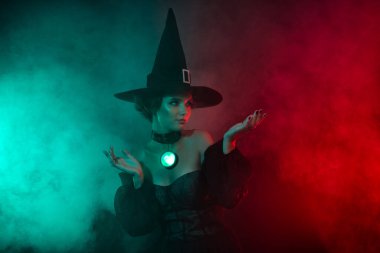 Korku büyücüsünün karanlık ormanlarda gezinip şeytani sisli arka planda izole bir şekilde ruh çağırma fotoğrafı..