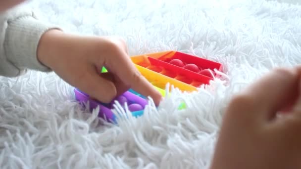 Дитина Грає Поп Сенсорною Іграшкою Дівчина Натискає Різнокольорові Веселкові Які — стокове відео