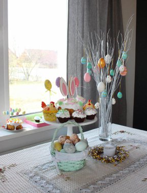 Paskalya 'da ev dekorasyonu. Paskalya yumurtaları vazonun içinde duran bir ağacın dallarında asılı. Kulaklı Paskalya pastası. Paskalya yumurtaları