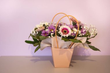 Şenlik kutusundaki çiçeklerin bir kompozisyonu merdivenlerde ışık altında duruyor. Sevilen bir kadın için hediye..