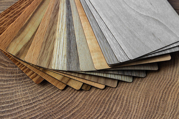 Sample of wood laminated chipboard for furniture design on wooden background with copy space. Color guide displaying a range of hues for use in interior design and decoration, for designers