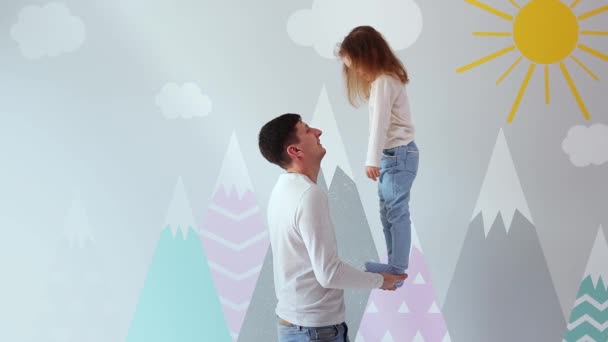 Malá Dívka Evropského Vzhledu Balancuje Otcově Ruce Pozadí Malované Zdi — Stock video