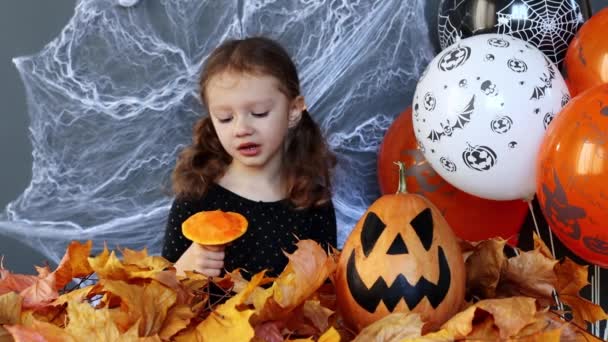 Little Witch Girl Funny Eating Slice Pumpkin Background Halloween Attributes — Stockvideo