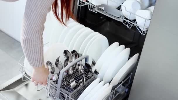 Молода Жінка Відкриває Двері Посудомийної Машини Виймає Чистий Білий Посуд — стокове відео