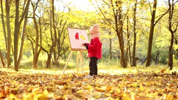 Mała Dziewczynka Czerwonym Płaszczu Maluje Akwarelę Sztaludze Parku Tle Jesiennego — Wideo stockowe
