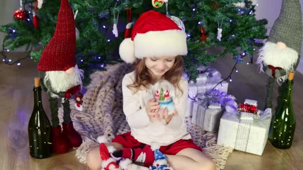 Little Girl Red Santa Hat Sitting Christmas Tree Playing Magic — Stockvideo