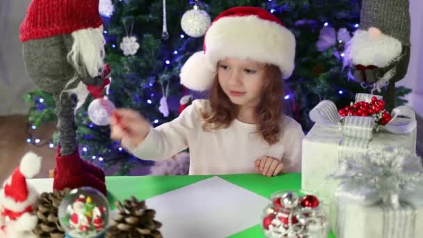 Маленькая Девочка Красной Шляпе Санты Пишет Письмо Санта Клаусу Своими — стоковое видео