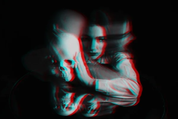 Assustador embaçado retrato de uma bruxa feminina com um crânio em suas mãos — Fotografia de Stock