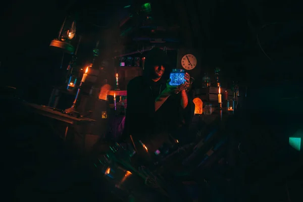 炼金术士手里拿着一瓶药水。术士在黑暗的实验室里是个巫师 — 图库照片