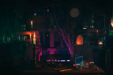 Simyacı cadıların mistik laboratuarının içinde. Mumlar ve şişelerde çeşitli iksirlerle.